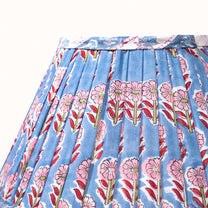 Blue pleated denim lampshade with a print of pink, red, and green flowers