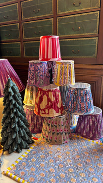 Blue pleated denim lampshade with a print of pink, red, and green flowers